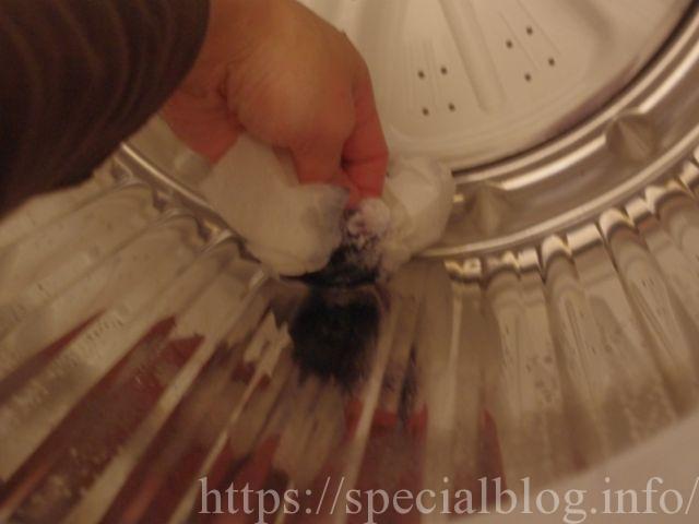 洗濯機にベッタリとついた油性ボールペンのインクを拭き取っているところ